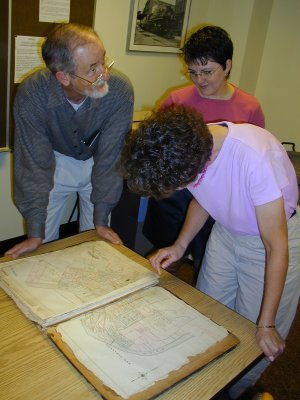 Tom Owen, Sherri Pawson and Margaret Merrick look at the 1884 Atlas of the City of Louisville. Photo by Bill Carner